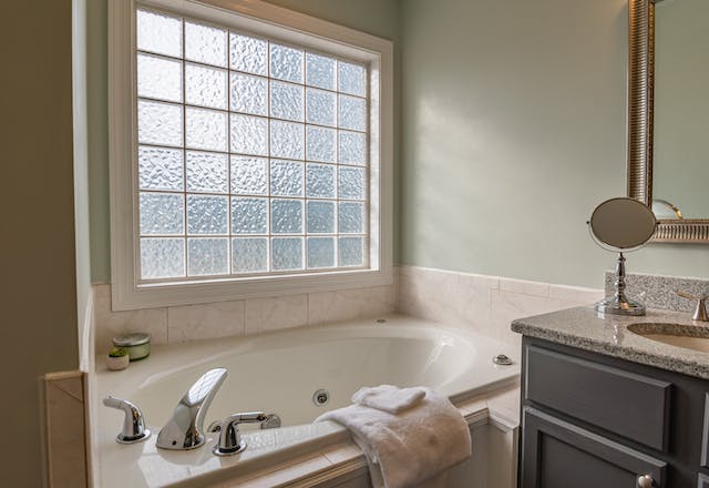 A bathroom interior with a large, textured window letting in a lot of natural light.